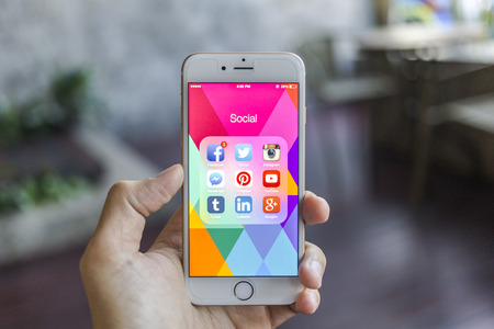CHIANG MAI, THAILAND - JANUARY 02, 2015: All of popular social media icons on smartphone device screen with hand holding on Apple iPhone 6.のeditorial素材