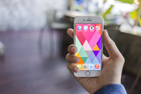 CHIANG MAI, THAILAND - JANUARY 02, 2015: All of popular social media icons on smartphone device screen with hand holding on Apple iPhone 6.のeditorial素材