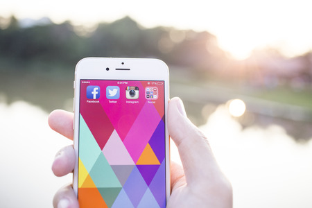 CHIANG MAI, THAILAND - JANUARY 02, 2015: All of popular social media icons on smartphone device screen with hand holding on Apple iPhone 6.のeditorial素材