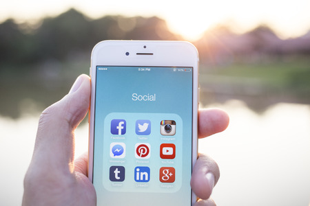 CHIANG MAI, THAILAND - JANUARY 02, 2015: All of popular social media icons on smartphone device screen with hand holding on Apple iPhone 6.のeditorial素材