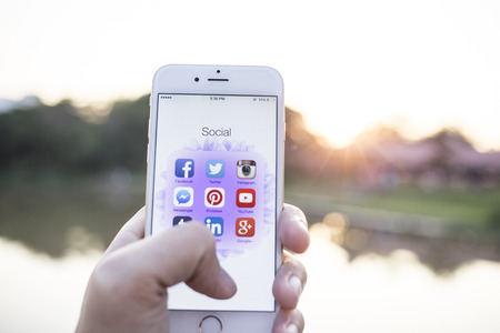 CHIANG MAI, THAILAND - JANUARY 02, 2015: All of popular social media icons on smartphone device screen with hand holding on Apple iPhone 6.のeditorial素材