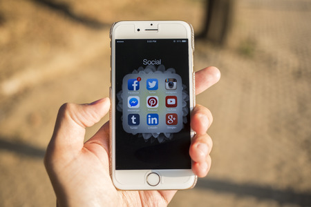 CHIANG MAI, THAILAND - JANUARY 04, 2015: All of popular social media icons on smartphone device screen with hand holding on Apple iPhone 6.のeditorial素材