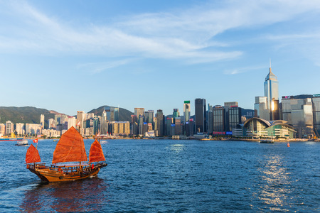 Hong Kong victoria habour with red ship and building in background.