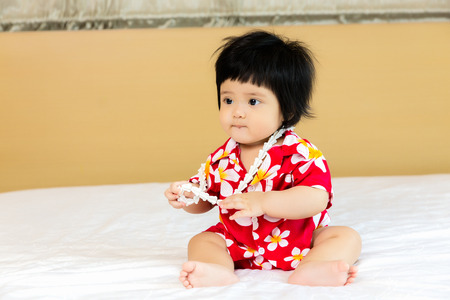 Adorable Asian child girl wearing flower shirt to celebrate Thai new year, Songkran or water festivalの写真素材