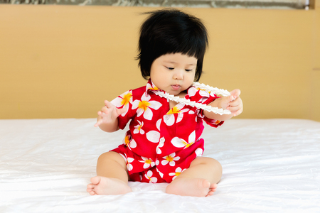 Adorable Asian child girl wearing flower shirt to celebrate Thai new year, Songkran or water festivalの写真素材