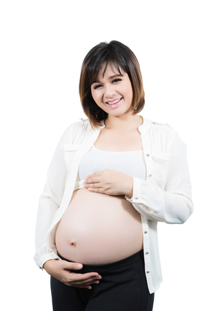 Portrait of the beautiful 9 month pregnant woman happy posing isolated on white backgroud.の写真素材