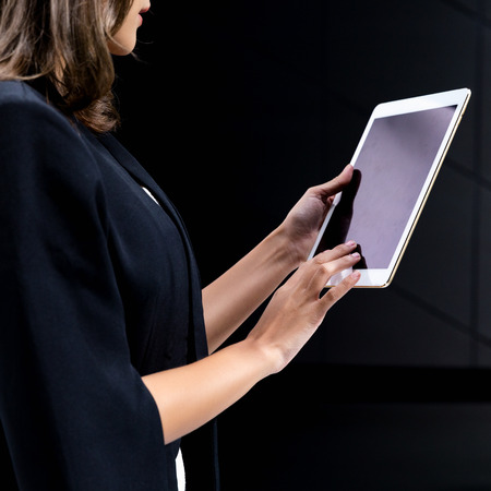 young women using digital tablet on black backgroundの写真素材