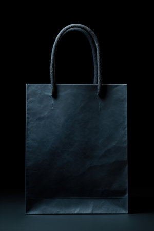 Black paper bag on black background. 3d rendering. Mock up.の素材
