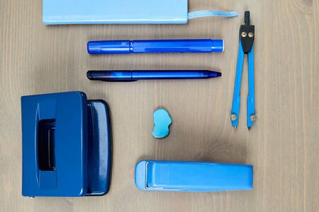 Desk with blue stationery. Wooden desk tidy with all office objects.の写真素材