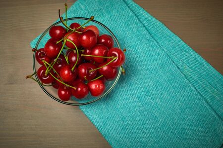 Green spring red cherries on wooden background selective focus cherryの写真素材