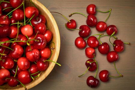 Green spring red cherries on wooden background cherry
