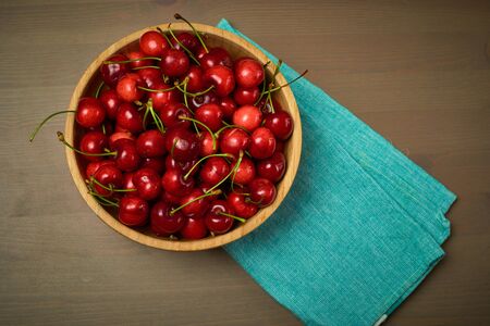 Green spring red cherries on wooden background selective focus cherryの写真素材