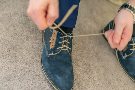 Man bonding up blue shoes laces.の写真素材
