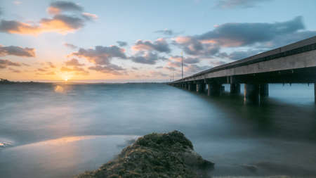 Long exposure of a bridge over the sea at sunset, long exposureの写真素材