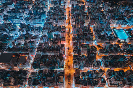 Aerial view of intersection in Hong Kong Downtown. Financial district and business centers in smart city, technology concept. Top view of buildings at night.の写真素材