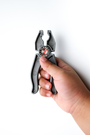 Baby holding a toy pliers, isolated on a white background