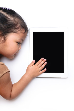 child playing on tablet, isolated on a white backgroundの写真素材