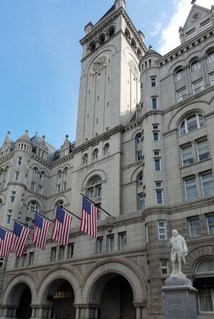 Washington DC, USA - September 29, 2019: Trump International Hotel entrance with the American flags and the statue of Benjamin Franklin, situated in the Old Post Office Tower historical building.のeditorial素材