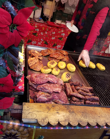 TIMISOARA, ROMANIA - DECEMBER 20, 2016: Man grills polenta, sausages, and meats at a Christmas food fair from the region of Maramures in Romania.のeditorial素材
