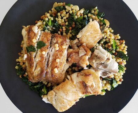 Healthy eating with a plate of baked white fish on a chickpea and spinach mix.の写真素材