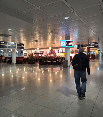 Munich, Germany â September 27, 2021: Man walking in an empty concourse in the Munich International Airport, due to the corona virus pandemic travel restrictions.のeditorial素材