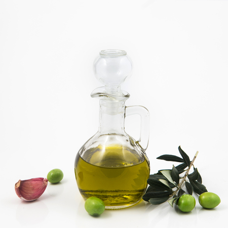 bottle with olive oil isolated on white background and, garlic peppersの写真素材