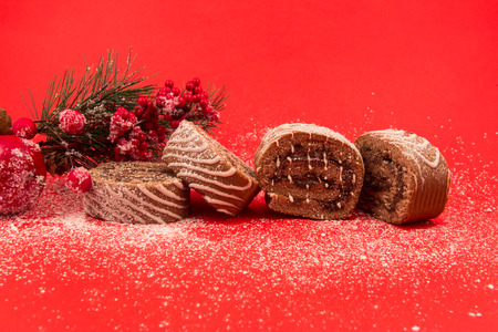 Christmas chocolate Swiss roll cake isolated on red background