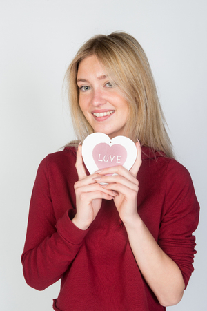 Beautiful young happy woman hold love symbol heart saint valentine day, isolated on white backgroundの写真素材