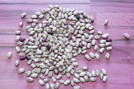 Raw pinto beans gold chickpeas on wooden board, healthy vegan food with a lot protein, macro shot