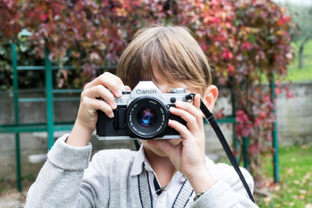 Trieste, Italy - October 22nd 2017: Camera Canon AE-1 35mm, baby taking pictures using vintage movie...