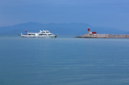 The white ship and beacon on a background of dark blue mountainsの写真素材