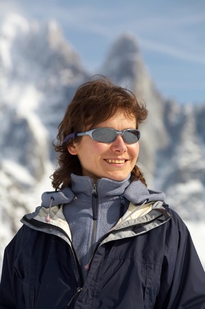 The girl in glasses on a background of snow mountainsの写真素材