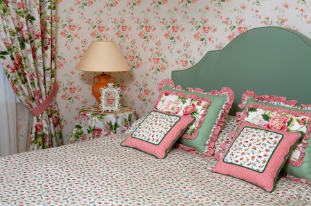 Interior of a bedroom with a lamp pillows a vegetative ornament