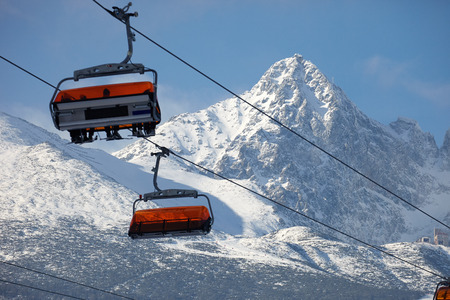 Cabin mountain lift with skiers on the mountain backgroundの写真素材