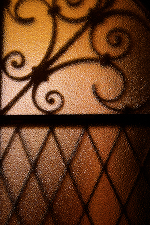 Shadow shaped metal grid on color glassの写真素材