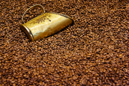 Old copper measuring cup in coffee beansの写真素材