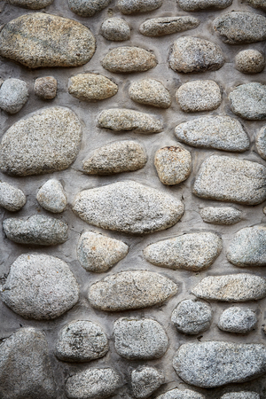 Stones background, gray large stones, boulders in the masonry, part of stone fence, close-up of stone borderの写真素材