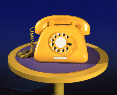 Vintage yellow sham phone on blue backgroundの写真素材