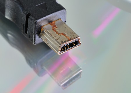 Rusty faulty USB connector on a grey background.