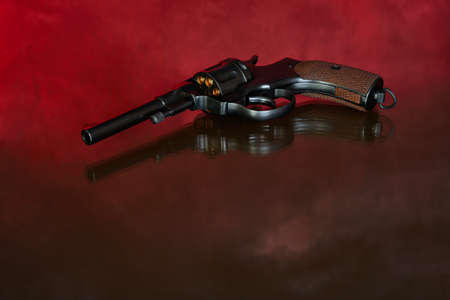 Revolver on red background. Vintage pistol revolver.