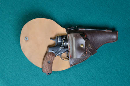 Gun with holster on a on green cloth.の写真素材
