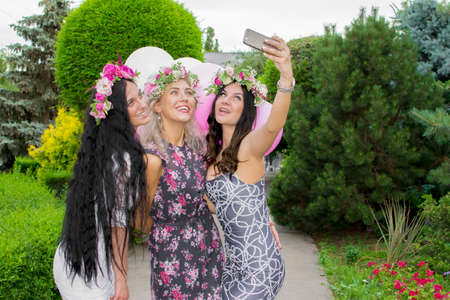 Group of happy women taking self-portrait on their travel vacations. Wearing colorful dress.の写真素材