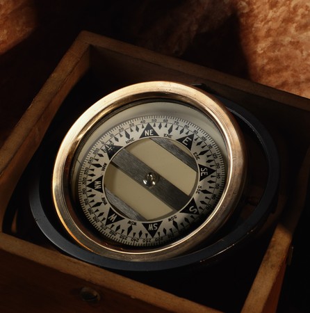 Nautical compass in a wooden box on brown backgroundの写真素材