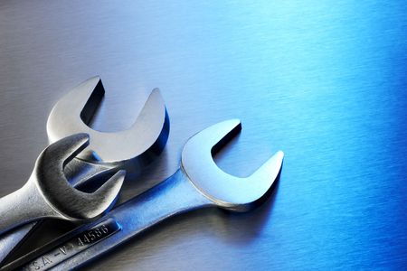 Close up shot of three wrenches shot on blue stainless steel backgroundの写真素材