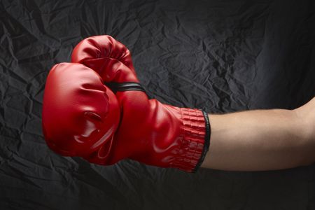 Boxer wearing red boxing glove about to land a punchの写真素材