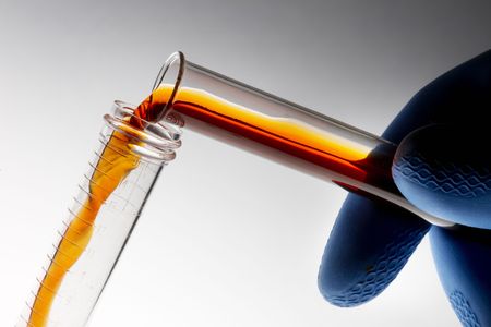 Lab technician pours chemical from test tube