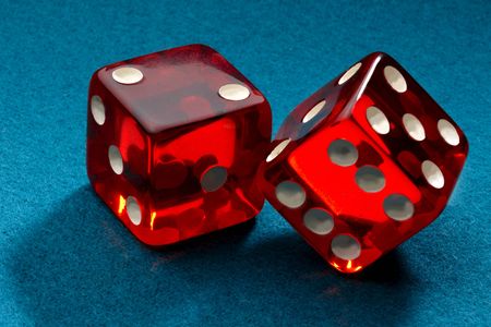 A pair of red transparent dice shot on blue feltの写真素材