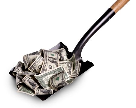 Shovel lifts dollar bills of a white backgroundの写真素材