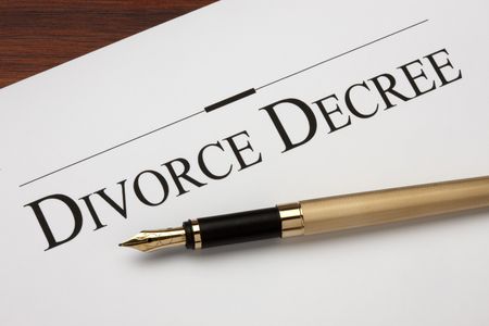 Divorce decree and gold fountain pen shot on warm wood surface