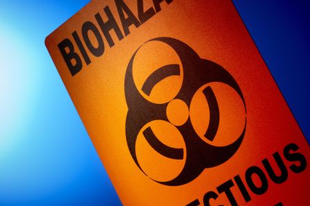 Orange biohazard sign dramatically shot in front of glowing blue backgroundの写真素材